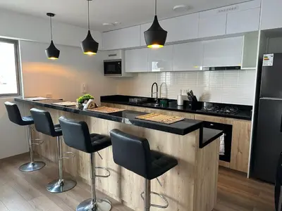 a kitchen with a counter with stools in it at No available in Lima