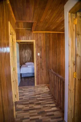 a wooden hallway with a bed in a room at Edelweisshaus Chontabamba in Oxapampa