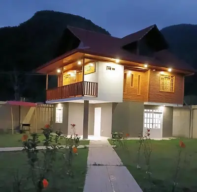 a house with a front elevation at night at Edelweisshaus Chontabamba in Oxapampa