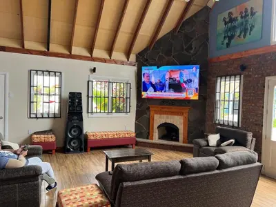 a living room with a fireplace and a tv at Villa Aurora in Aucallama
