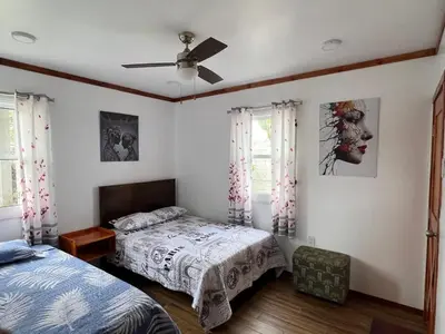 a bedroom with two beds and a ceiling fan at Villa Aurora in Aucallama