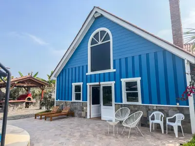 a blue church with white chairs and a patio at Villa Aurora in Aucallama