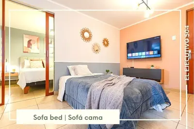 a bedroom with a bed and a flat screen tv at Vibrant Exclusive 1BR Apt in front of Casa Andina in Lima