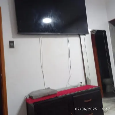 a room with a black suitcase and a tv at Colibri in Lima