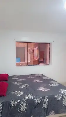 a bedroom with a bed and a window with clothes at Colibri in Lima