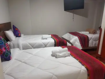 a living room with two beds and a couch at Retama Lodging in Cusco