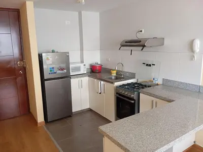 a kitchen with a refrigerator and a stove top oven at Departamento con piscina ubicado en Breña in Lima