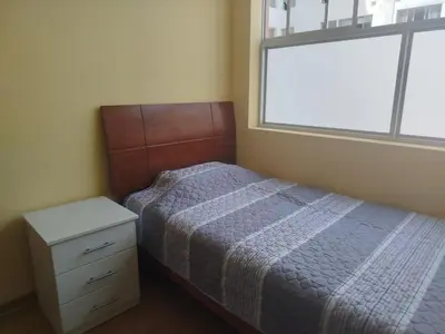 a small bedroom with a bed and a window at Departamento con piscina ubicado en Breña in Lima