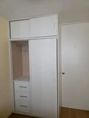 a closet with a large white cabinet and a door at Departamento con piscina ubicado en Breña in Lima