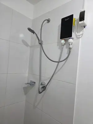 a shower with a shower head in a bathroom at Departamento con piscina ubicado en Breña in Lima