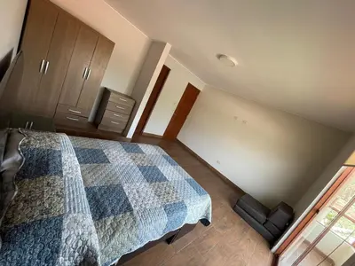 a bedroom with a bed with a blue checkered blanket at Casa Huertos CIENEGUILLA in Cieneguilla