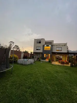 a house with a lawn in front of a building at Casa Huertos CIENEGUILLA in Cieneguilla