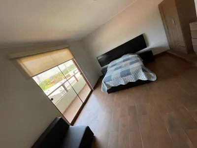 a bedroom with a bed and a sliding glass door at Casa Huertos CIENEGUILLA in Cieneguilla