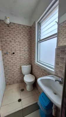 a bathroom with a toilet and a sink and a window at Hospedaje Casa de Liz Cusco in Cusco