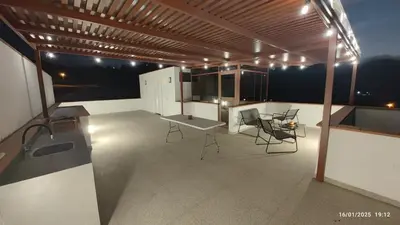 a patio with a table and chairs on a roof at Casa de campo en condo cerca a playa Puerto Viejo in San Antonio
