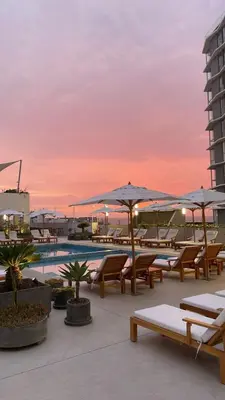 a pool with chairs and umbrellas on a building at Rosita del Mar in San Bartolo