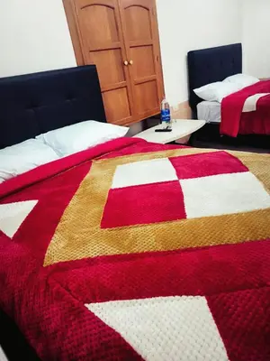 a bedroom with two beds with a red and white quilt at Casa Centro Historico Cusco in Cusco