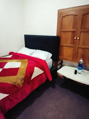 a bedroom with a bed and a table with a bottle of water at Casa Centro Historico Cusco in Cusco