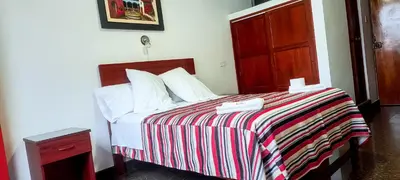 a bedroom with a bed with a striped blanket at Plaza Hotel Huánuco in Huánuco