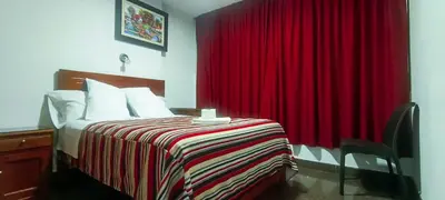 a bedroom with a bed with a red curtain at Plaza Hotel Huánuco in Huánuco