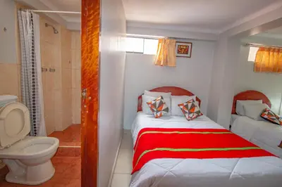 a small bathroom with a bed and a toilet at AloInkaHotels in Cusco
