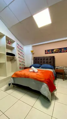 a bedroom with a large bed with an orange blanket at Templo de la Luna Pardo in Cusco