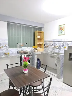 a kitchen with a wooden table with chairs and a stove at Samin House in Cusco