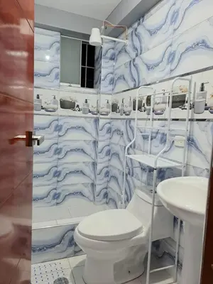 a blue and white bathroom with a toilet and sink at Samin House in Cusco