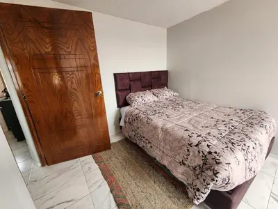 a bedroom with a bed and a wooden door at Casa Mirador SanBlas Quilla in Cusco