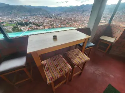 a table and chairs with a view of a city at Casa Mirador SanBlas Quilla in Cusco