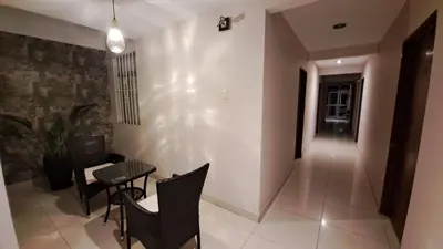 a room with chairs and a table and a hallway at Hospedaje Las Vegas in San Vicente de Cañete