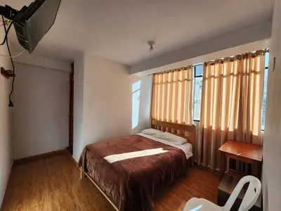 a small bedroom with a bed and a window at Sol de América in La Unión