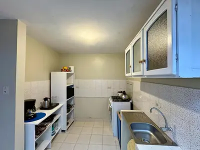 a small kitchen with blue cabinets and a sink at Tika house in Cusco
