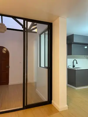 a glass door in a room with a kitchen at Habitaciones casa Bella in Lima