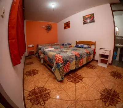 a bedroom with a bed and orange walls at Hostal Luren - Parking in Nazca