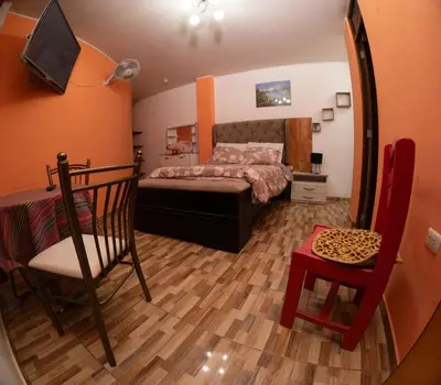a bedroom with a bed and a table and a chair at Hostal Luren - Parking in Nazca