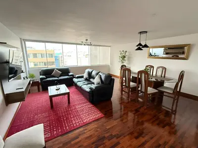 a living room with a couch and a table at Dpto Benavides la paz miraflores in Lima