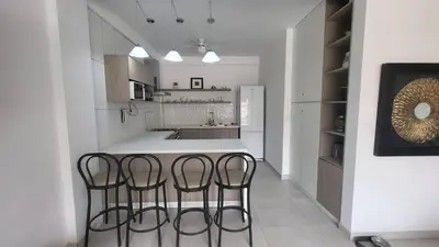 a kitchen with three bar stools in front of a counter at Little Oasis in Lima penthouse with pool, Grill, nice view, gated community in Ciudad de Dios
