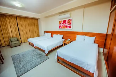 a hotel room with two beds and a rug at Grima Hotel in Huánuco