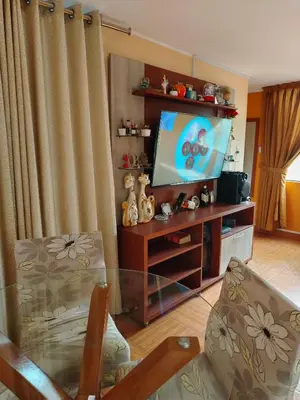 a living room with a flat screen tv on a entertainment center at Departamento en Sjl in Lima