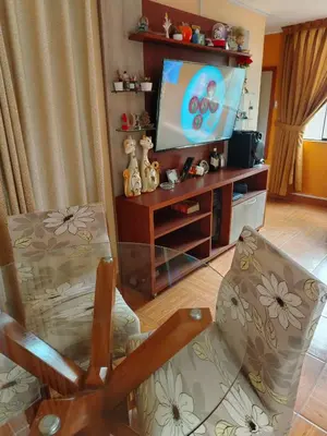 a living room with a chair and a flat screen tv at Departamento en Sjl in Lima