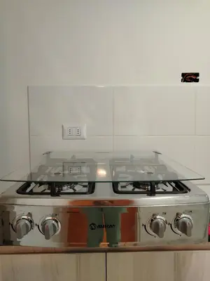 a stove top oven with a glass counter top at Depa con piscina 2025 in Lima