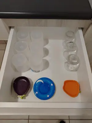 a drawer filled with dishes and glasses on a shelf at Depa con piscina 2025 in Lima
