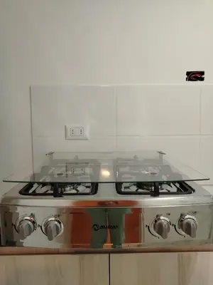 a stove top oven with a glass counter top at Depa con piscina 2025 in Lima
