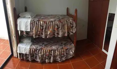 a small bed in a room with a table at Casa Hospedaje Las Lomas con piscina en La Merced in La Merced