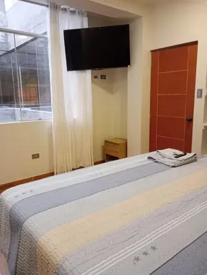 a bedroom with a bed with a flat screen tv at Exclusivo Depa Cerca Precio Uno para 10 in La Merced