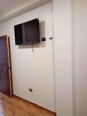 a wall with a flat screen tv on a white wall at Exclusivo Depa Cerca Precio Uno para 10 in La Merced