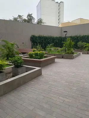 a courtyard with benches and plants in front of a building at Departamento de Estreno in Lima