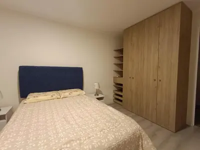 a bedroom with a bed and a wooden cabinet at Departamento de Estreno in Lima