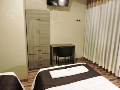 a bedroom with a bed and a desk and a chair at EmbajadaWanka in Huancayo